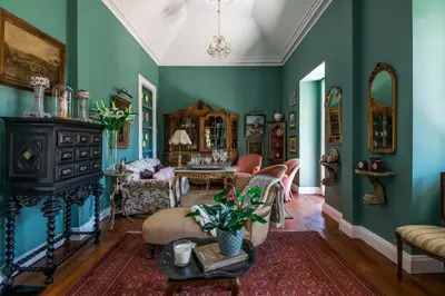 a living room with green walls and a table at Villa Camélia Boutique House in Camacha
