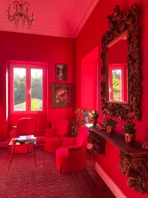 a red living room with red chairs and a mirror at Villa Camélia Boutique House in Camacha