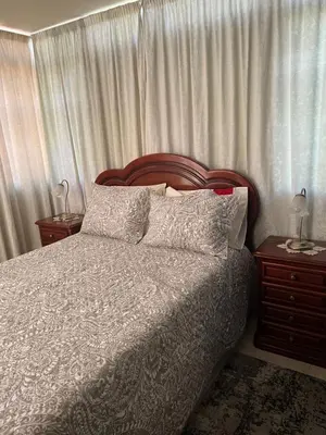 a bedroom with a bed and two nightstands with two lamps at Angie’s apartment in Funchal