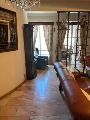 a living room with a leather couch and a chandelier at Angie’s apartment in Funchal