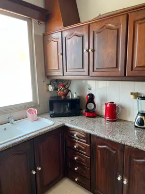 a kitchen with wooden cabinets and a counter top at Angie’s apartment in Funchal