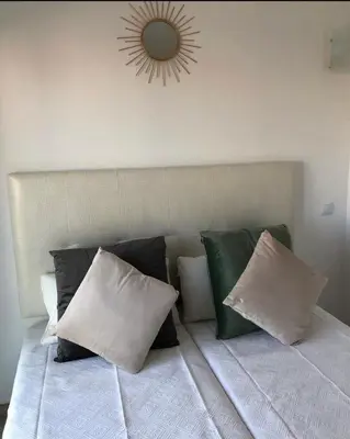 a bed with pillows and a mirror on the wall at ORANGE guest house in Sagres