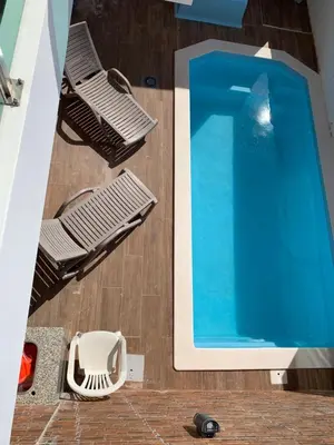 a swimming pool with two chairs next to a table at ORANGE guest house in Sagres