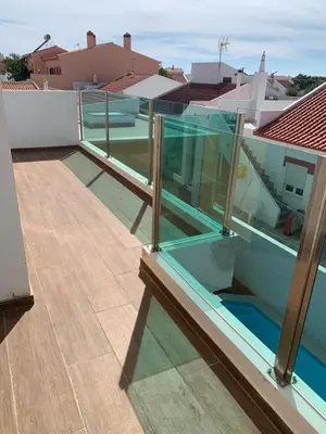 a balcony with glass railing on a house at ORANGE guest house in Sagres