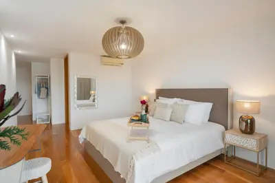 a bedroom with a large white bed and a table at Villa das Quebradas by An Island Apart in Funchal