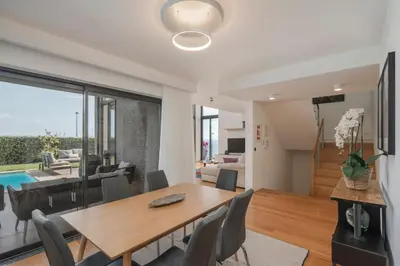 a dining room and living room with a table and chairs at Villa das Quebradas by An Island Apart in Funchal