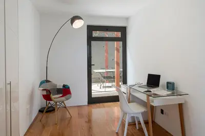 a white room with a desk with a laptop and chairs at Villa das Quebradas by An Island Apart in Funchal
