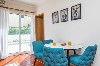 a dining room with a table and blue chairs at Porto Moniz City Centre by Homie in Porto Moniz