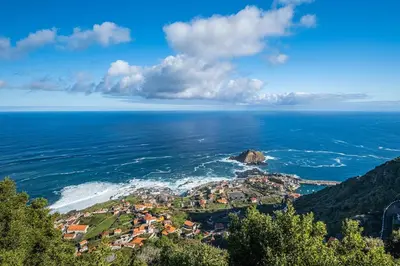 an aerial view of the ocean and a small town at Porto Moniz City Centre by Homie in Porto Moniz