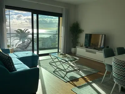 a living room with a glass table and a television at Ines Seaview Apartment in Funchal