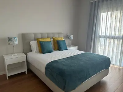 a bedroom with a large bed with blue and yellow pillows at Ines Seaview Apartment in Funchal