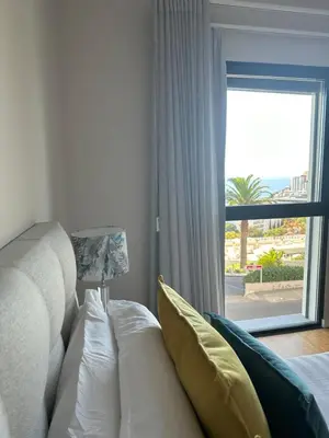 a living room with a couch and a large window at Ines Seaview Apartment in Funchal
