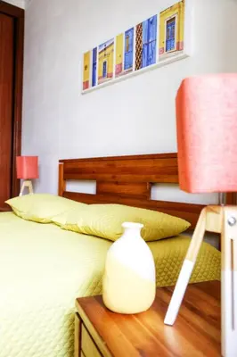 a bedroom with a bed with a vase on a table at Arrifana Beach House - T2 Haller in Aljezur