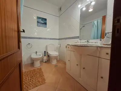 a bathroom with a toilet and a sink and a mirror at Arrifana Beach House - T2 Haller in Aljezur