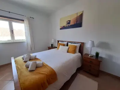 a bedroom with a large bed with two pillows on it at Arrifana Beach- T2 Sun & Surf Flat in Aljezur