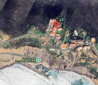 a wooden bench sitting on top of a beach at Arrifana Beach- T2 Sun & Surf Flat in Aljezur