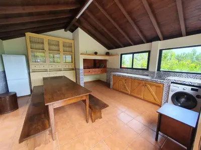 a kitchen with a table and a washing machine at Mountain-Ocean-View Madeira in São Vicente