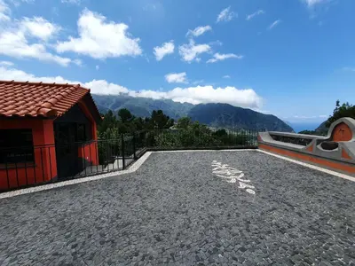 a cobblestone driveway with a house and mountains in the background at Mountain-Ocean-View Madeira in São Vicente