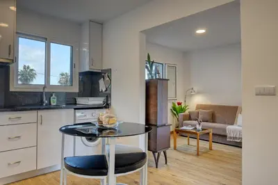 a kitchen and living room with a table and a couch at Casa Familia Pestana 2, a Home in Madeira in Seixal