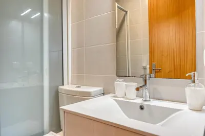 a bathroom with a sink and a toilet and a mirror at Casa Familia Pestana 2, a Home in Madeira in Seixal