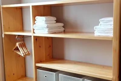 a closet with wooden shelves and white towels at Villa Carvalhal in Funchal