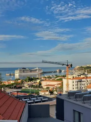 a view of a city with a crane and the ocean at Villa Carvalhal in Funchal