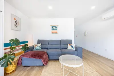 a living room with a blue couch and a table at The Kuuyi Suite in Burgau