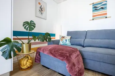 a living room with a blue couch and a plant at The Kuuyi Suite in Burgau