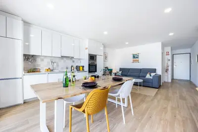 a kitchen and living room with a wooden table and chairs at The Kuuyi Suite in Burgau