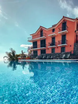a swimming pool in front of a pink building at Ocean View Madeira 1 - Ponta do Sol in Canhas
