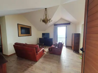 a living room with two leather chairs and a chandelier at Ocean View Madeira 1 - Ponta do Sol in Canhas