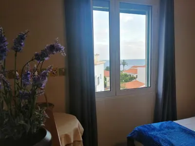 a room with a window with a vase of purple flowers at Duplex da Fontinha in Santa Cruz