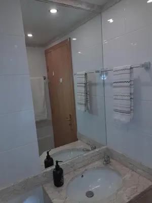a bathroom with a sink and a large mirror at Duplex da Fontinha in Santa Cruz
