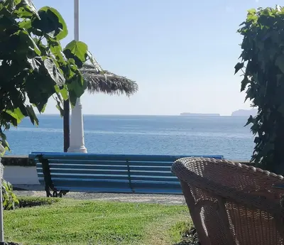 a bench sitting in front of the ocean at Duplex da Fontinha in Santa Cruz