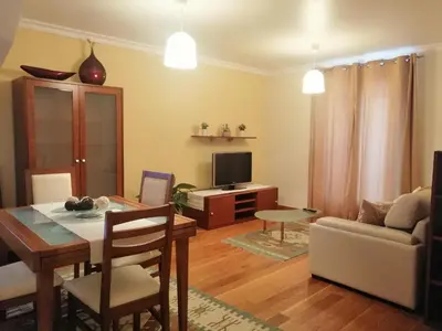 a living room with a table and a couch at Duplex da Fontinha in Santa Cruz
