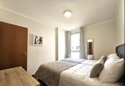 a bedroom with a large bed and a window at Wings Apartment in Santa Cruz