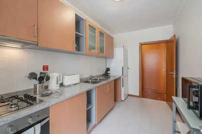 a kitchen with wooden cabinets and a counter top at Wings Apartment in Santa Cruz