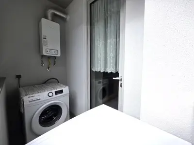 a laundry room with a washing machine and a window at Wings Apartment in Santa Cruz
