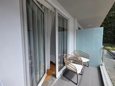 a balcony with two chairs and a window at Wings Apartment in Santa Cruz