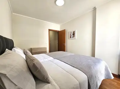 a bedroom with a large bed with white sheets at Wings Apartment in Santa Cruz