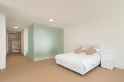 a bedroom with a white bed and a green wall at Villa Camacho - Ultra Luxury in Calheta