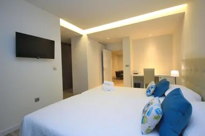 a bedroom with a large white bed with blue pillows at Villa Camacho iv - Mansion House in Arco da Calheta