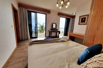 a bedroom with a large bed and a large window at Ocean View Madeira 3 - Ponta do Sol in Canhas