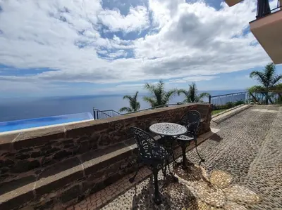 a patio with a table and chairs and the ocean at Ocean View Madeira 3 - Ponta do Sol in Canhas