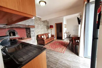a kitchen and living room with a stone fireplace at Ocean View Madeira 3 - Ponta do Sol in Canhas