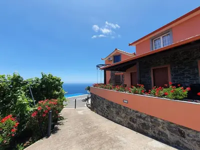 a house with flowers on the side of it at Ocean View Madeira 3 - Ponta do Sol in Canhas