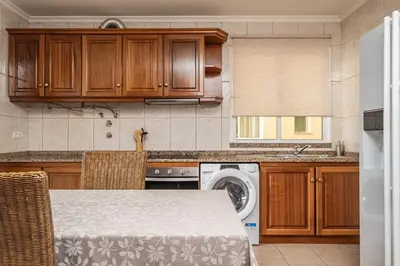 a kitchen with a table and a washing machine at Bela Vista Sea View in Venda do Atalhinho