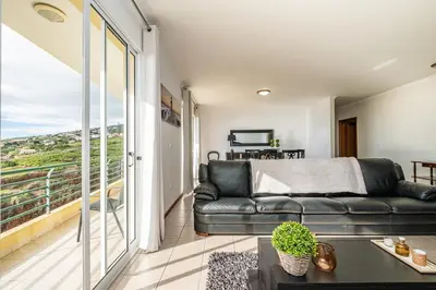 a living room with a couch and a balcony at Bela Vista Sea View in Venda do Atalhinho