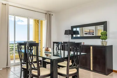 a dining room with a table and chairs and a mirror at Bela Vista Sea View in Venda do Atalhinho