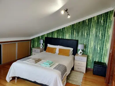 a bedroom with a large bed with a green wallpaper at Beautiful View 2 - Arco da Calheta - Ilha da Madeira in Arco da Calheta